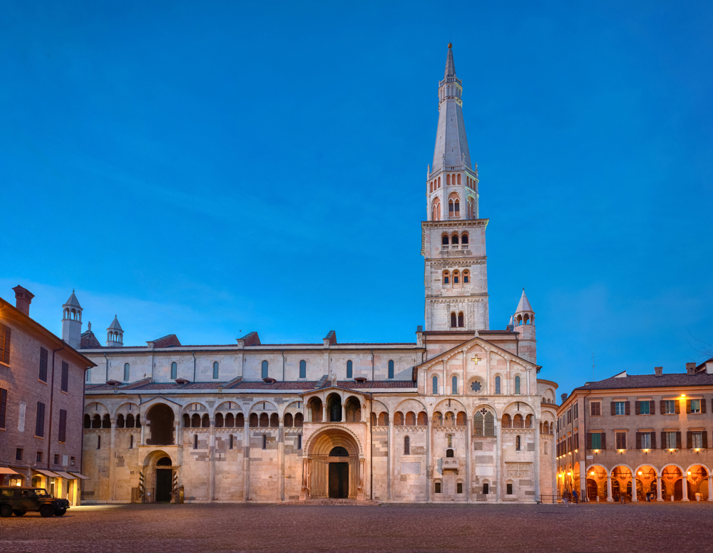 Modena, Italy. View of Cathedral with Ghirlandina tower located on Piazza Grande at dusk