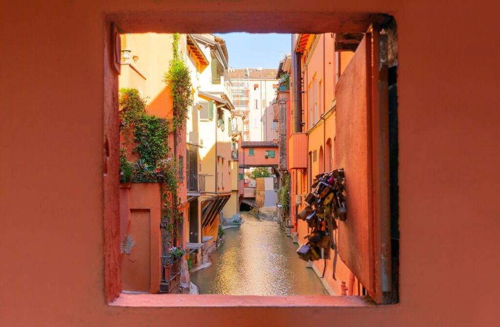 Secret window in the wall to the hidden part of the city in Bologna, Italy. Canal of Reno in Piella street
