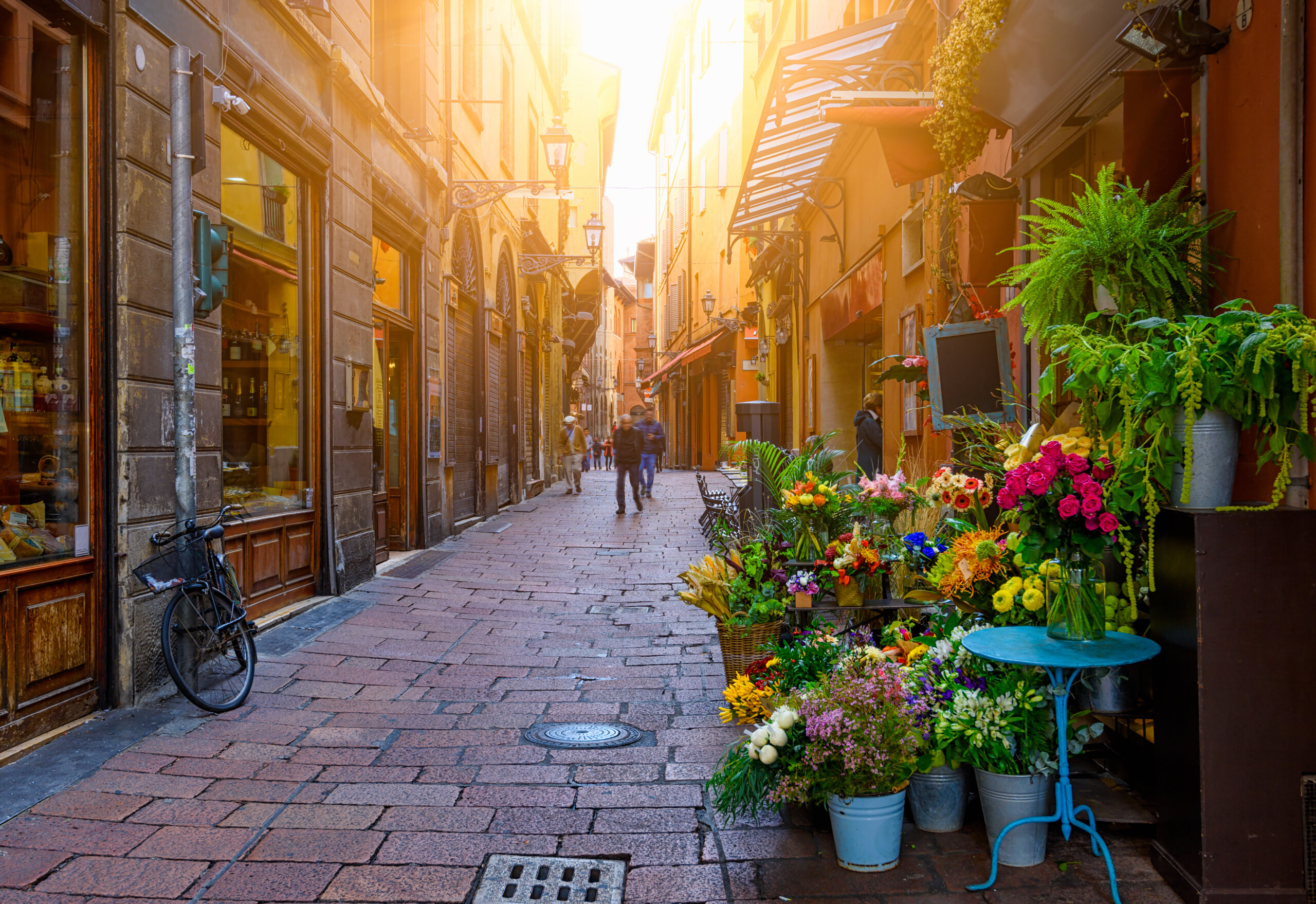 Stara wąska ulica z kwiaciarnią w Bolonii, Emilia Romania, Włochy. Pejzaż miasta Bolonia