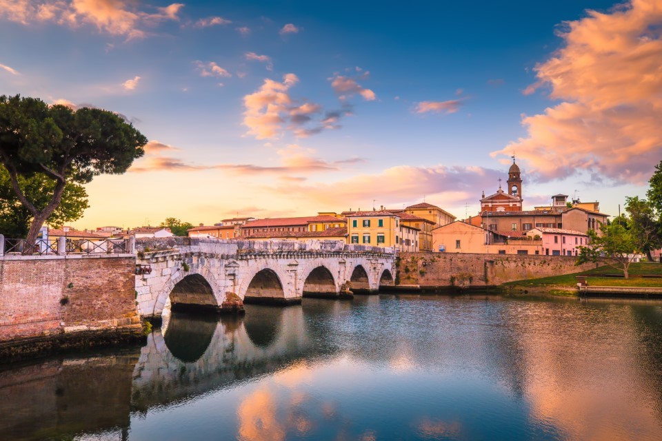 Pejzaż miejski w Rimini. Tyberiusz most słynne zwiedzanie w Rimini o świcie. Letni wschód słońca w historycznym centrum Rimini.