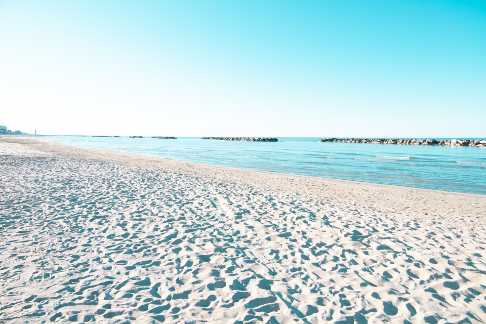 Intentionally overexposed shot of the beach of Bellaria Igea Marina, in the riviera Romagnola area on the Adriatic coast. Usually crowded, now deserted due to social distancing and sanitary emegency