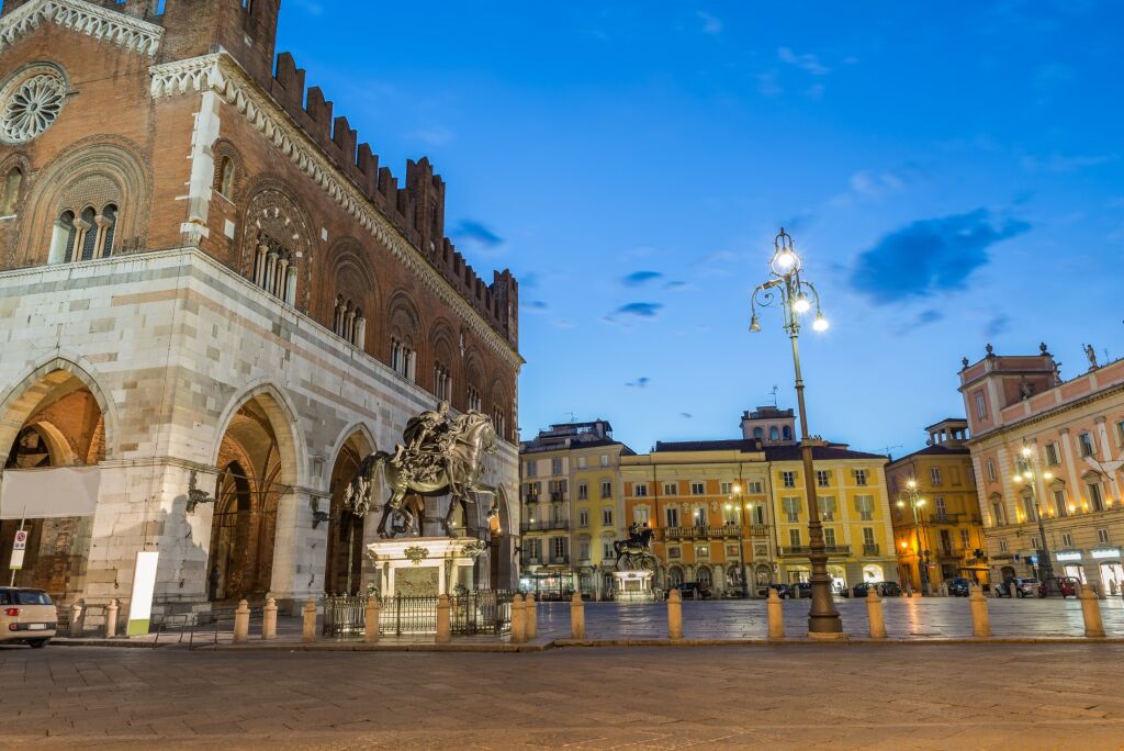 Medieval city at dusk. Piacenza, historic center, Italy. Piazza Cavalli (Square horses) with palazzo Gotico (Gothic palace - XIII century) and Governor's palace on the right, Emilia Romagna