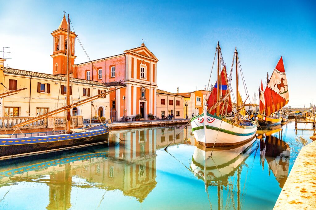 Church and ancient saiboats on Leonardesque gat in Cesenatico in Italy
